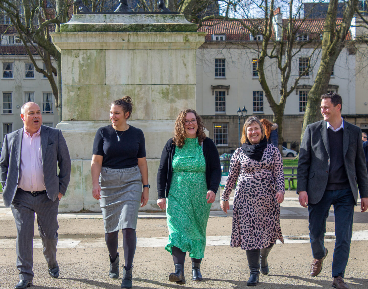 5 people from the Albert Goodman team walking in a line, smiling